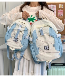 Detail of canvas outdoor backpack featuring blue mesh side pockets and penguin patch detail
