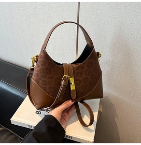 Detailed view of leopard print suede and leather bag with golden turn-lock fastener