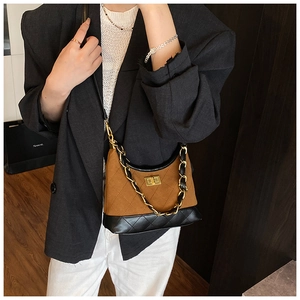 Detail of quilted leather underarm bag with gold twist lock and woven chain strap