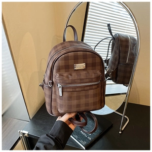 Détail d'un mini sac à dos vintage à carreaux marron montrant la texture et le logo