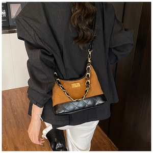 Detail of vintage quilted crossbody bag with brown suede and black glossy leather
