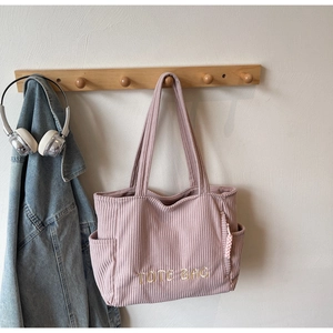 Détail du cabas en velours côtelé rose poudré avec broderie TOTE BAG et poche latérale