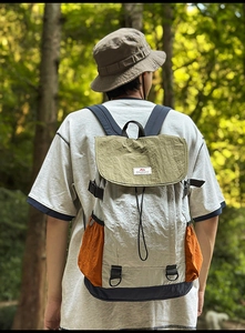 Detail of multi-color nylon outdoor backpack with drawstrings and green flap cover