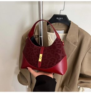 Detail of burgundy leather and leopard print suede hobo bag with golden metal clasp