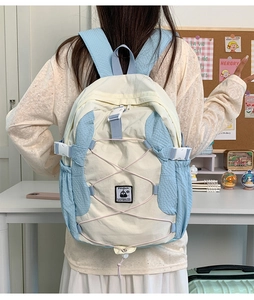 Detail showing the adjustable blue shoulder straps and back view of the beige school backpack