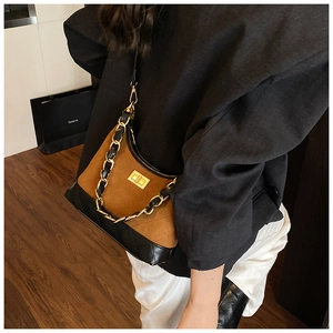 Detail of vintage quilted underarm bag with gold twist-lock and chain strap on model