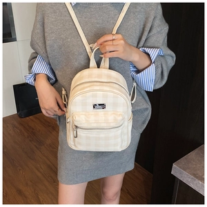 Détail du mini sac à dos beige à carreaux avec bretelles réglables et poches zippées