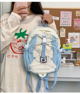 Detail view of water-resistant nylon backpack with crisscross bungee cord and buckle clasp