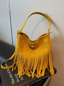Fashionable mustard yellow suede fringe bucket bag with golden metallic twist lock closure
