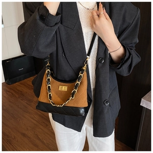 Detail of vintage quilted leather bag featuring a gold chain strap and buckle closure