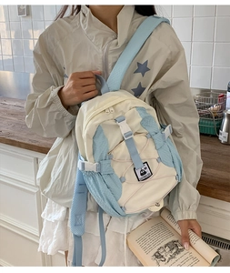 Detail of lightweight beige and light blue backpack with front bungee cord and buckles
