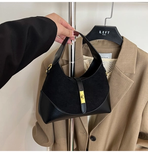 Macro detail of the black contrast dumpling bag with premium gold metallic buckle lock