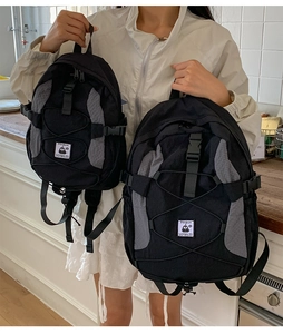 Size comparison of casual black and grey backpacks with elastic bungee cord details