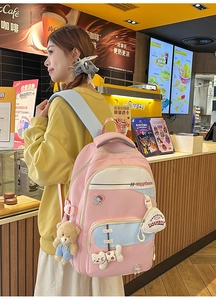 Close-up of pink backpack featuring cute capybara embroidery and plush bear pendant