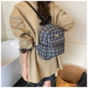 Détails du sac à dos rétro à carreaux avec logo en métal et fermeture éclair sur modèle