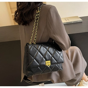 Detailansicht der schwarzen gesteppten Ledertasche mit goldener Kette und Drehverschluss