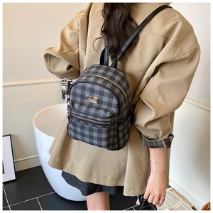 Sac à dos chic à carreaux gris sur mannequin en blazer beige pour un style décontracté