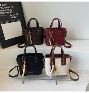 Vier Vintage-Eimertaschen in Braun, Burgund, Schwarz und Beige mit Holzperlenanhängern