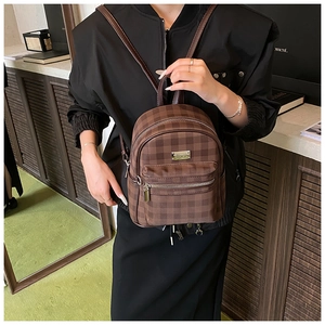 Détail d'un mini sac à dos à carreaux vintage avec plaque en métal et fermetures