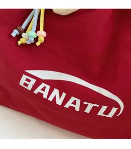 Detail von rotem Nylongewebe mit BANATU-Logo und bunten Kordelzügen mit Perlen