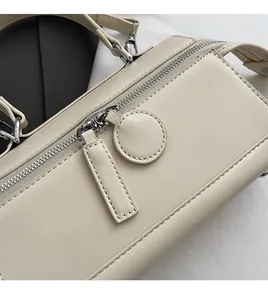 Close-up of beige leather texture and silver zipper details on the stylish pillow bag