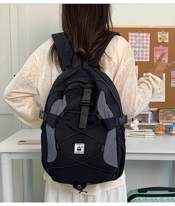 Close-up of lightweight black school backpack with Penguin logo on soft study background