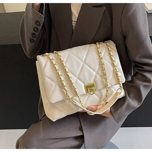 Detailansicht des goldenen Drehverschlusses und der gesteppten weißen Lederhandtasche