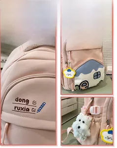 Detailed view of pink school backpack with house-shaped pocket and cute puppy pendant