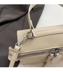 Close-up of premium silver hardware and neat stitching on a beige leather handbag