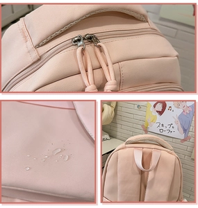 Close-up of pink water-resistant nylon backpack showing zippers and fabric texture