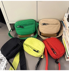 Flat lay of colorful nylon crossbody bags in green beige black yellow and red colors