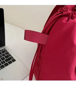 Detail eines purpurroten Nylon-Rucksacks mit strukturiertem Stoff und Gurtband