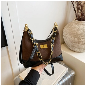 Close-up of brown quilted suede shoulder bag with golden chain strap and square buckle