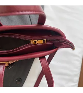Detail der weinroten Lederhandtasche mit goldenem Reißverschluss und feinen Nähten