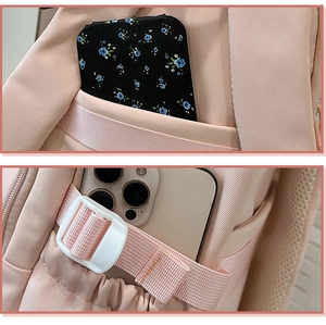 Detail view of pink backpack showing side pockets and adjustable breathable mesh straps