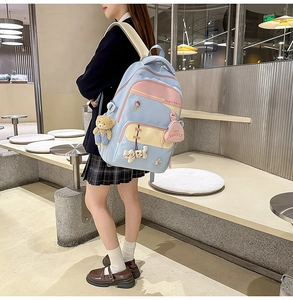 Detail of multi-color casual backpack with cute charms and capybara print for students