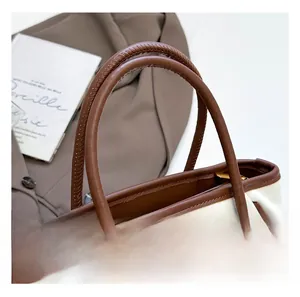 Detail of premium leather handle with fine stitching on a vintage bucket handbag