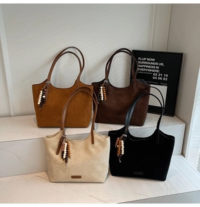Detail of minimalist suede tote bags in four colors with decorative beaded tassels