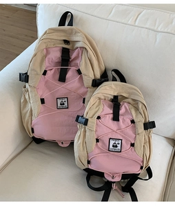 Detail of pink and beige nylon backpacks set with buckle and bungee cord design