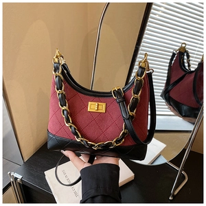 Detailed view of the burgundy quilted suede texture and golden metal twist lock on the bag