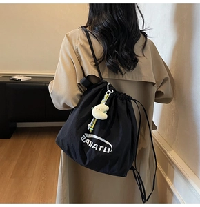 Detail eines schwarzen Nylon-Rucksacks mit BANATU-Logo und einem Stern-Plüschanhänger
