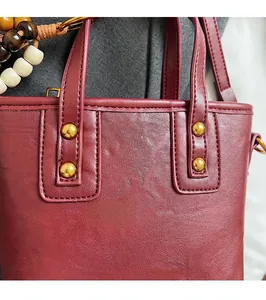Detail der weinroten Lederbeuteltasche mit Nieten und böhmischem Perlenarmband