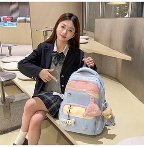 Detail of multi-pocket patchwork backpack with cute plush pendants and capybara print