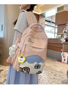 Pink school backpack featuring cartoon house prints and a cute plush toy pendant