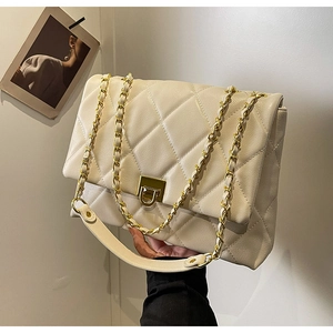 Detail der cremefarbenen Stepptasche mit goldener Kette und edlem Drehverschluss