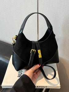 Contrast material dumpling bag in black leather and suede with elegant gold buckle strap