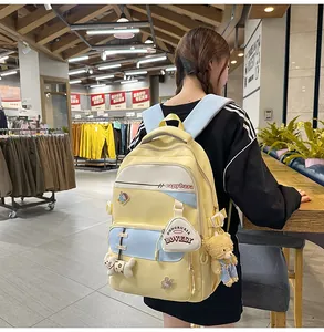Detail shot of a yellow and blue school backpack with cute cartoon badges and accessories