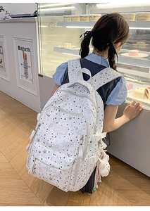 Detail view of large capacity white star print backpack with cute plush charm accessory