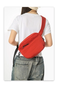 Detailed back view of a red lightweight nylon crossbody bag with adjustable black strap
