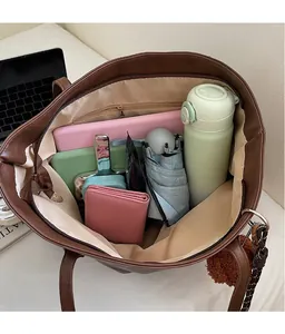 Detailed view of spacious brown tote bag interior with multiple everyday items organized